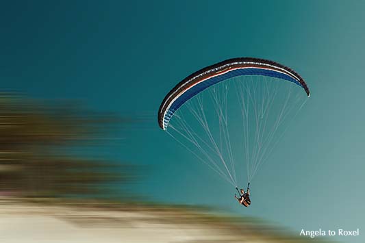 Fotografie: Im Sommerwind, Paraglider fliegt über der Dune du Pilat, setzt zur Landung an, unscharfer Hintergrund | Ihr Kontakt: Angela to Roxel