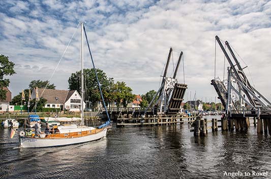 Geöffnete Holzklappbrücke über den Ryck, davor ein Segelboot, bereit zur Durchfahrt - Greifswald