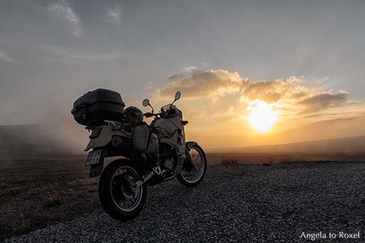 Parkendes Motorrad am Nordkap, dahinter die tiefstehende Mitternachtssonne, Nordkap, Insel Magerøya