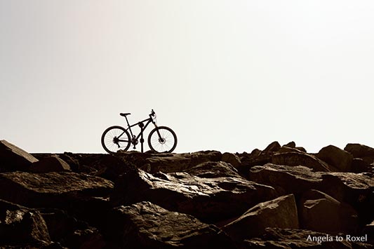 Fahrrad steht auf Felsblöcken, Gegenlicht,  Las Teresitas