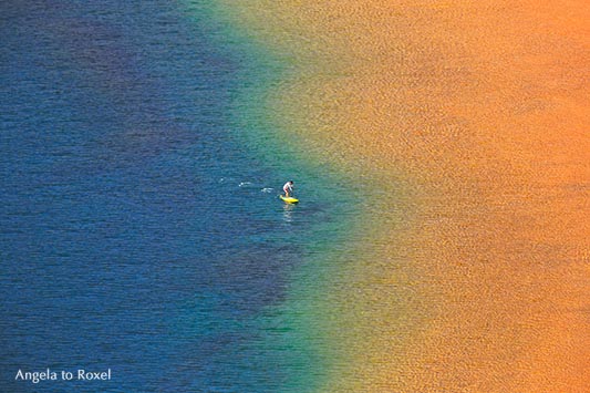 Fotografie: Over the Rainbow, einzelne Person mit Stehpaddel an der Küste, Stand Up Paddling, Regenbogenfarben in Las Teresitas