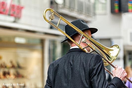 Fotografie Bilder kaufen: Trombone man walking, Mann geht mit einer Posaune auf der Schulter durch die Stadt, City, Bielefeld | Angela to Roxel