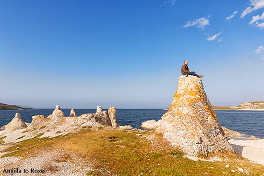 Hiker sitting on one of the legendary dolomite rocks on Porsangerfjorden, near Lakselv, Porsanger, Porsáŋgu, Porsanki, Finnmark County, Norway 