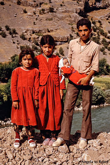 Fotografie: Vier Geschwister, zwei Mädchen und ein Junge mit einem Baby im Arm stehen am Straßenrand, Provinz Hakkari, Türkei 1986 | Angela to Roxel