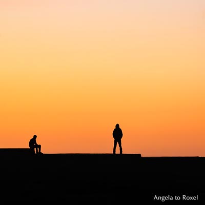 Fotografie: Mann auf einer Mauer, sitzt, steht, Silhouette, Sonnenuntergang im Hafen, Essaouira, Marokko | Ihr Kontakt: Angela to Roxel