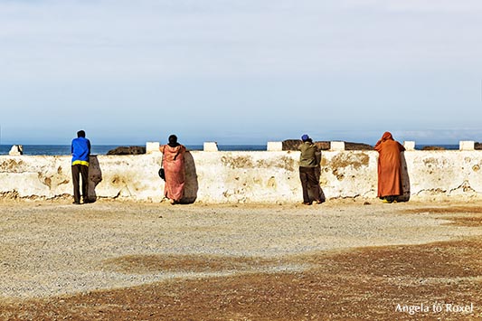 Menschen an der Hafenmauer von Essaouira schauen auf das Meer - Marokko 2014