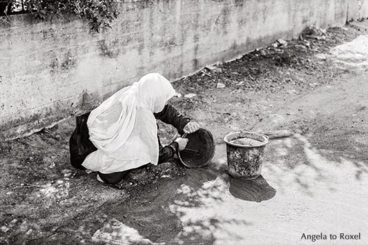 Drusische Frau in den Golanhöhen, säubert die Straße, analog, monochrom - Golanhöhen 1980