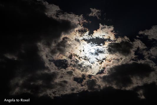 Fotografie: Sehr dunkler, stark bewölkter Himmel, Sonne hinter dunklen Wolken, dramatische Atmosphäre, Gegenlicht, Blick nach oben - Stockfoto