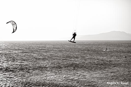 Kitesurfer an der Costa de la Luz, Abendstimmung in Tarifa, eine der „Welthauptstädte“ für Wind- und Kite-Surfer, monochrom, Gegenlicht - Andalusien