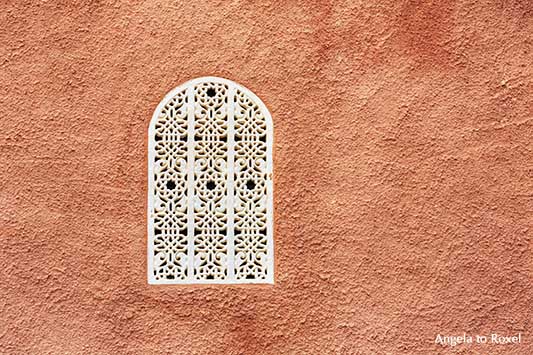 Fenster in Cortijo Cabrera, maurischer Baustil, weißes Fenstergitter mit arabeskem Muster in terrakottafarbener Wand, Turre, Andalusien - Angela to Roxel