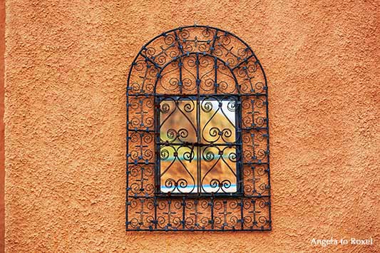 Arabeskes Gitter vor einem Spiegel in einem terrakottafarbenen Patio in Cortijo Cabrera, maurischer Baustil in Andalusien, Spanien - Angela to Roxel